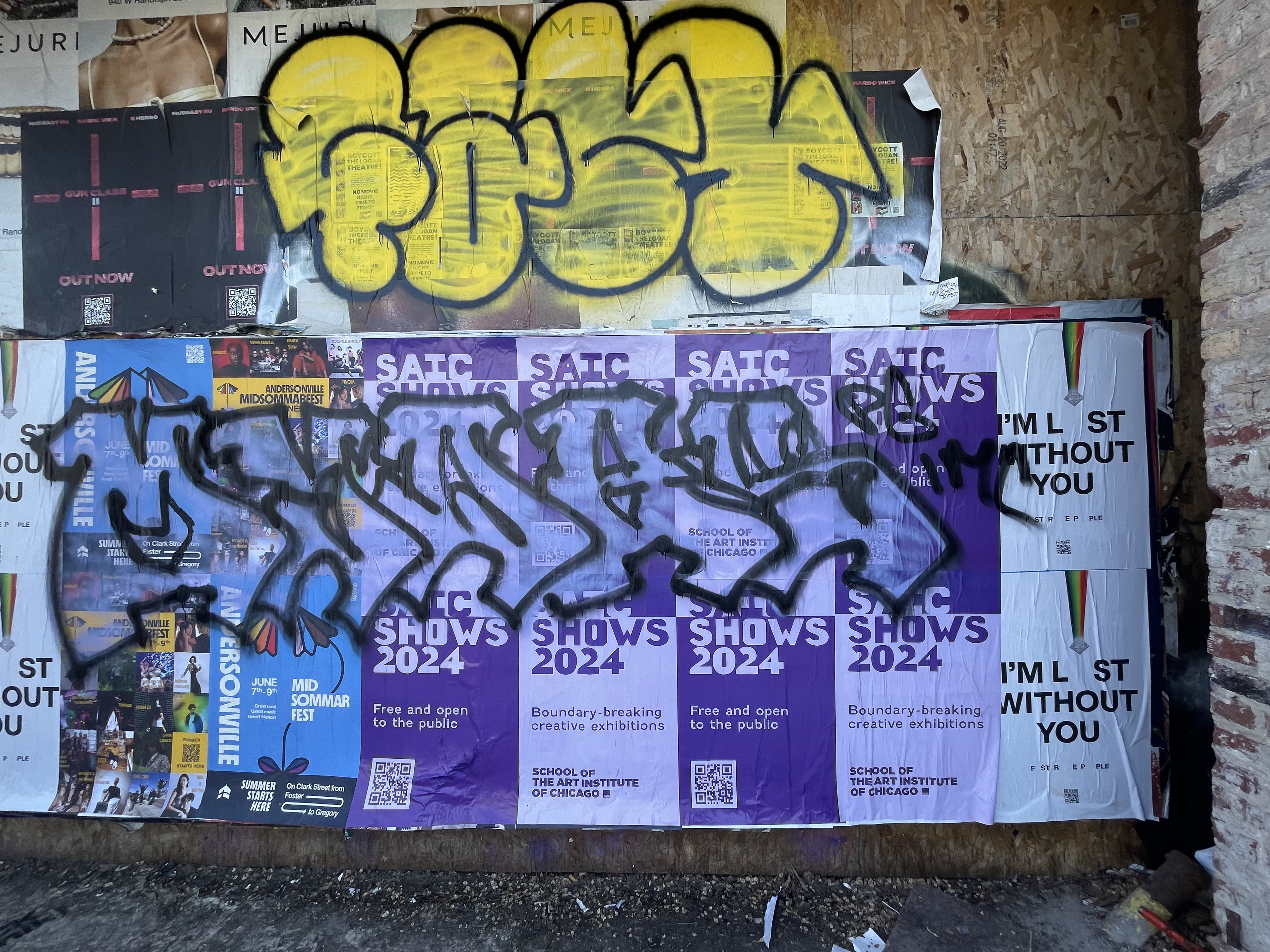 Graffiti Tags Layered Over Posters on a Wall