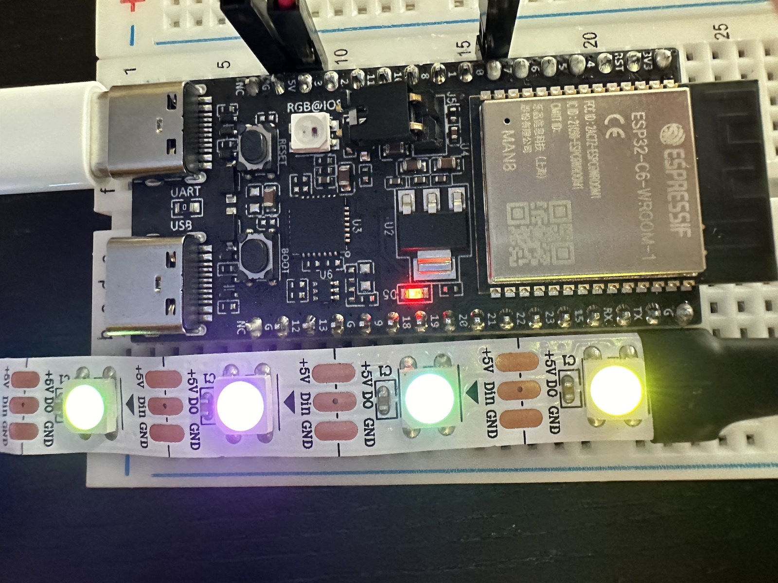 An ESP32-C6-DevKitC-1 board driving a lit WS2812 LED strip.