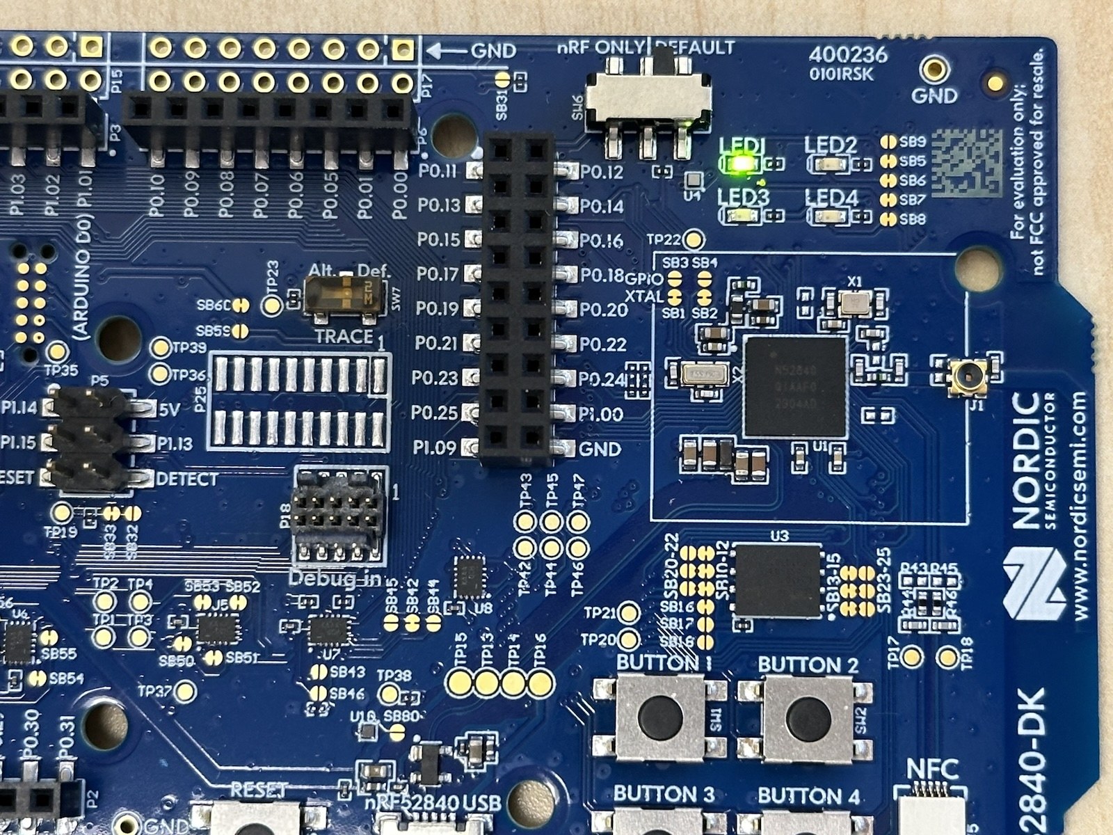 An nRF52840-DK board with its onboard LED lit.