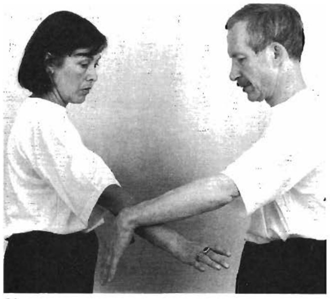 B luồn tay trái từ ngoài vào dưới cùi chỏ A