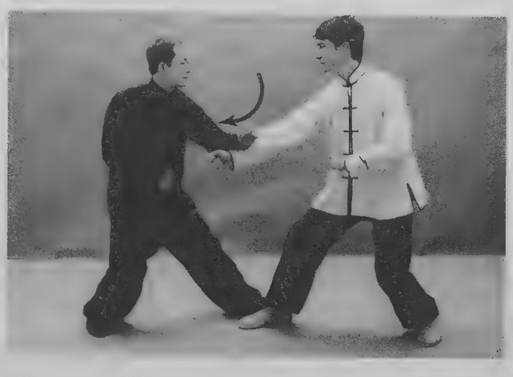 Hai người đối luyện, một người đấm và một người gạt xuống