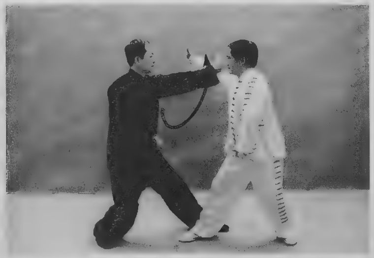 Đen dồn trọng lượng ra sau và vòng tay trái lên chặn đòn của Trắng
