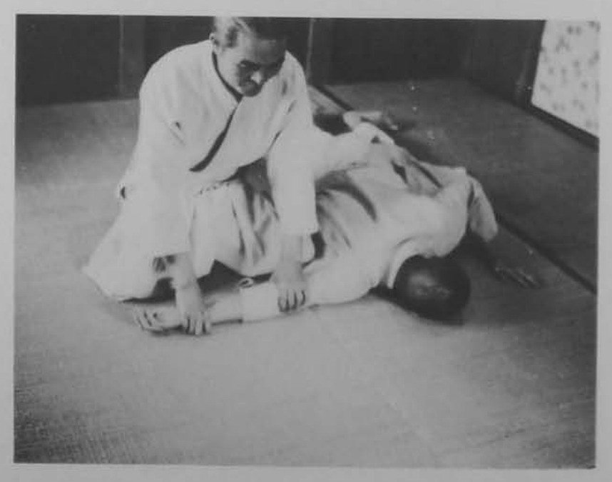 Shite nắm cổ tay và khóa cùi chỏ, vật đối phương xuống chiếu.