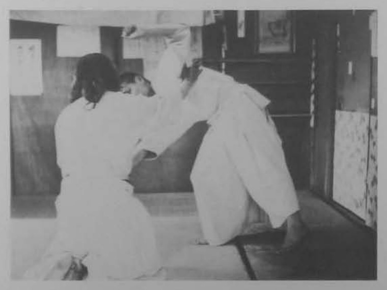 Quỳ gối trái, nắm tay áo kéo ngã đối phương.