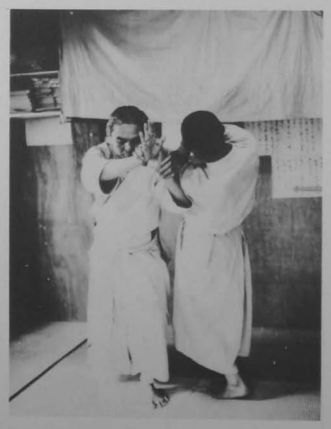 Nắm tay trái đối phương, vung lên và chém xuống.