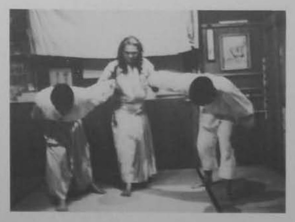 Võ sư cùng hai môn sinh cúi người: thế khống chế hai người.