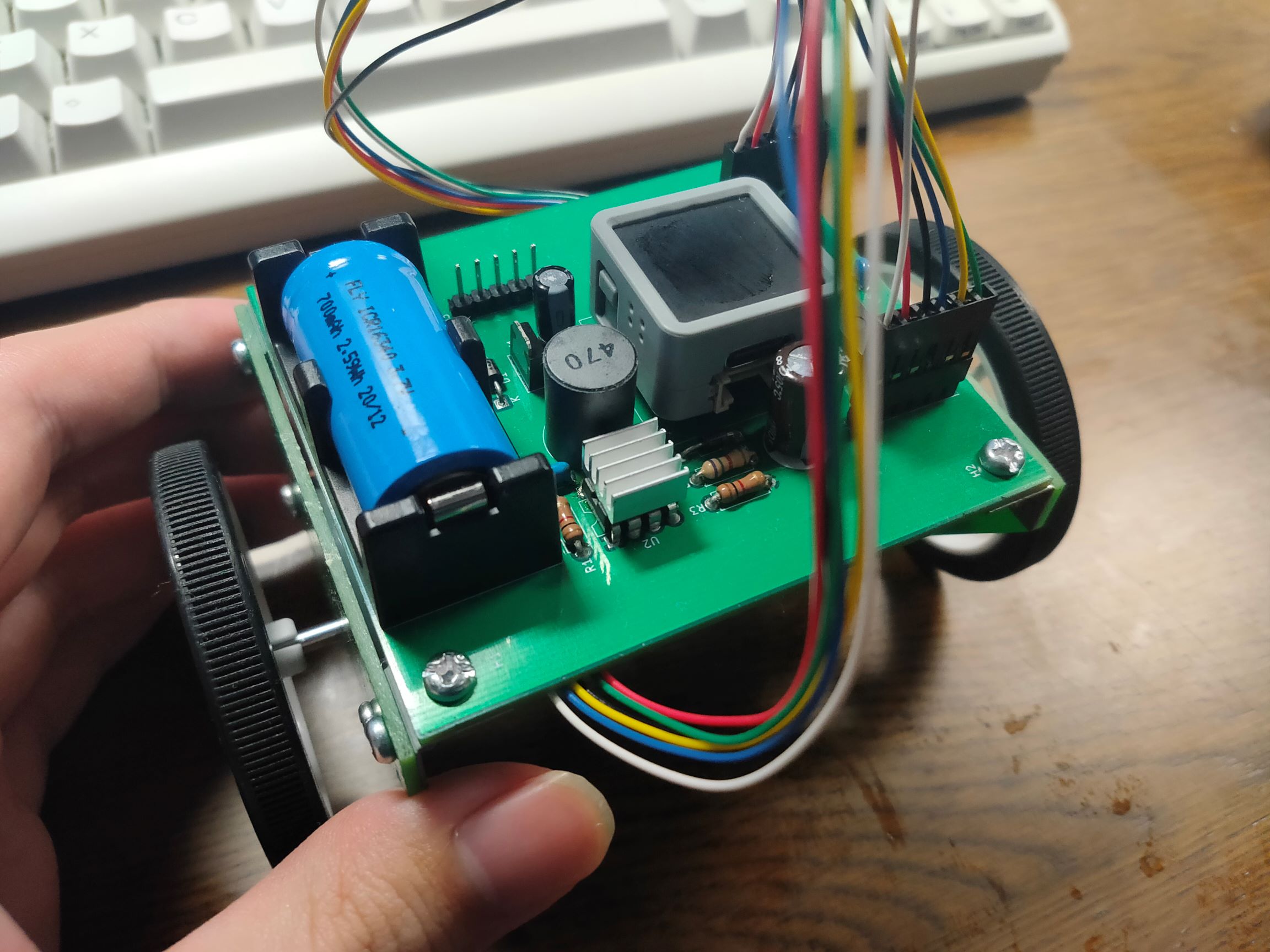 Photograph of a self-balancing robot. An Atom Matrix, a 16340 Li-ion battery, a DC-DC converter, and a stepper motor driver is mounted on a PCB. Two wheels are driven by two stepper motors.