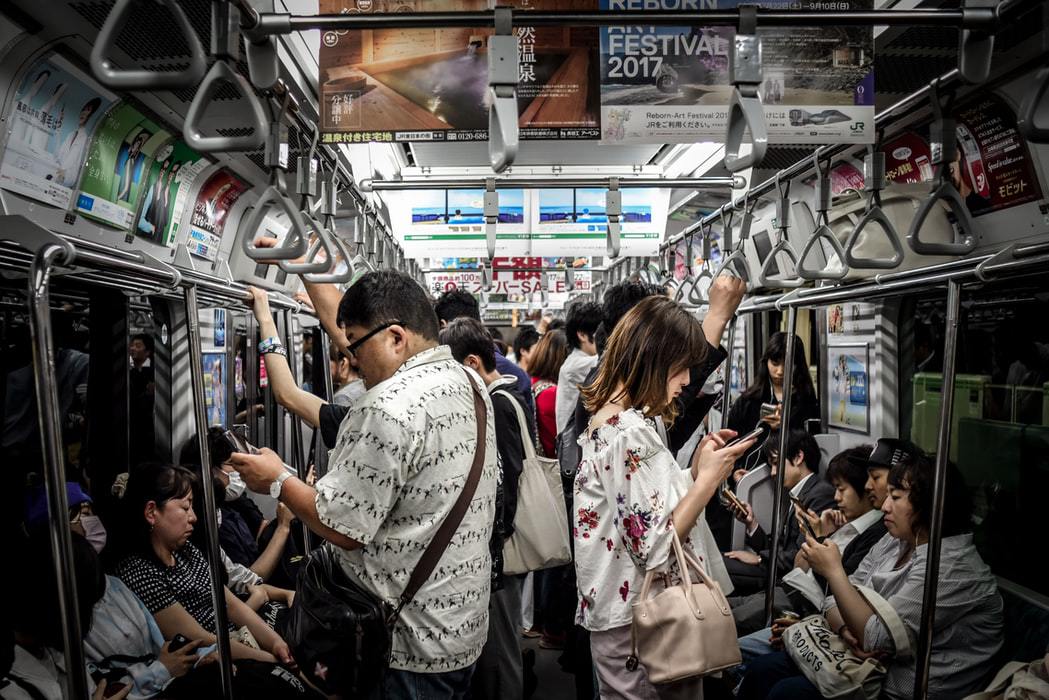 Personas usando sus celulares en el metro de Japón