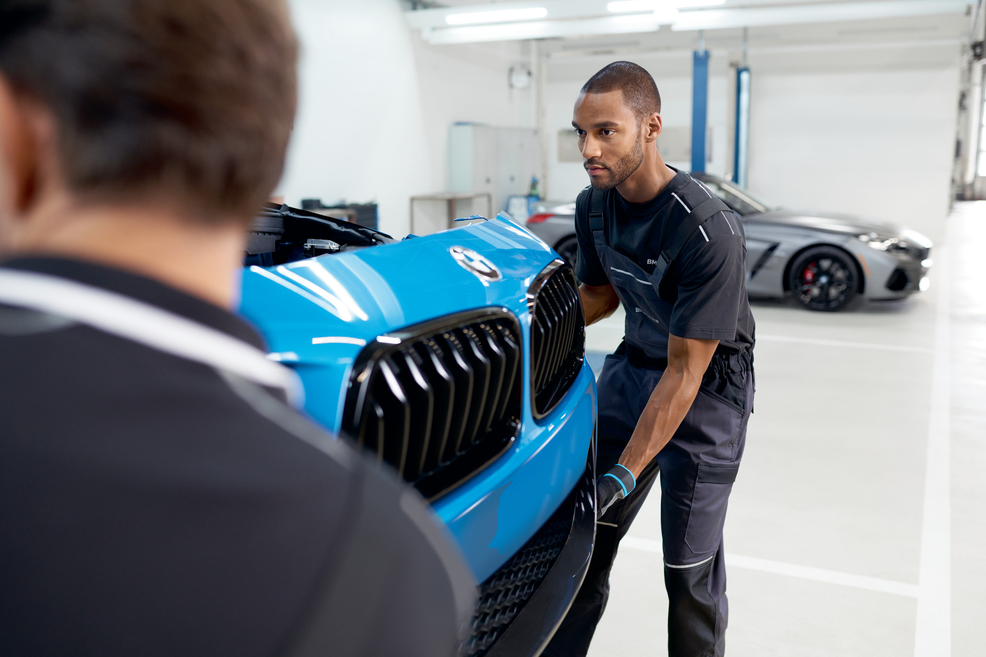 BMW technician performing front-end collision repair work