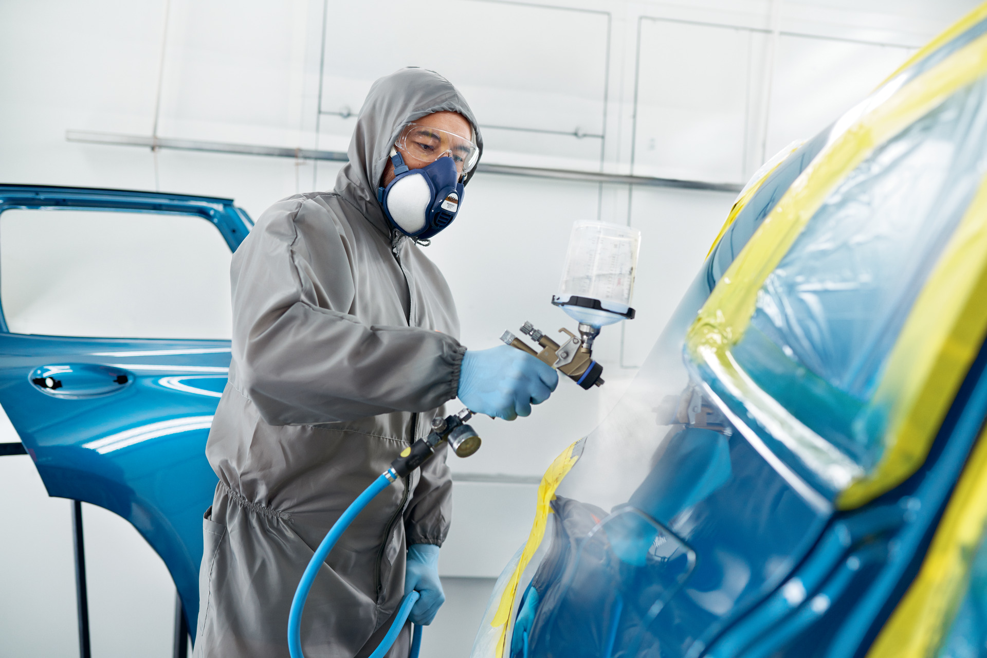 BMW body refinishing work in a certified collision repair paint booth