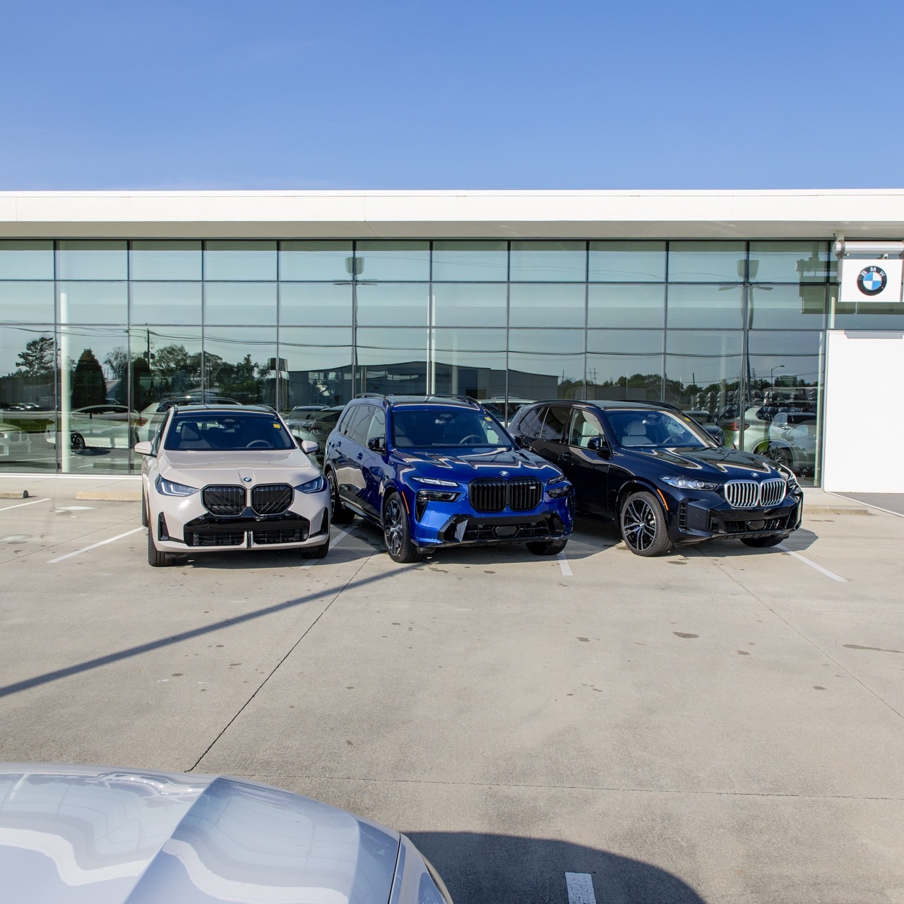 BMW X3, X5, and X7 parked in front of Brian Harris BMW