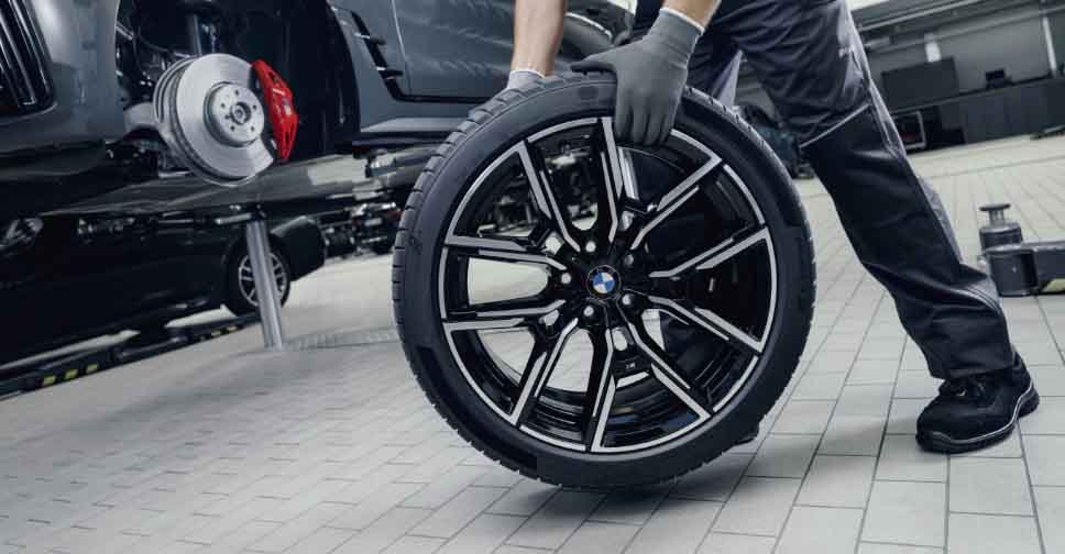 BMW technician fitting a Genuine BMW wheel and tire