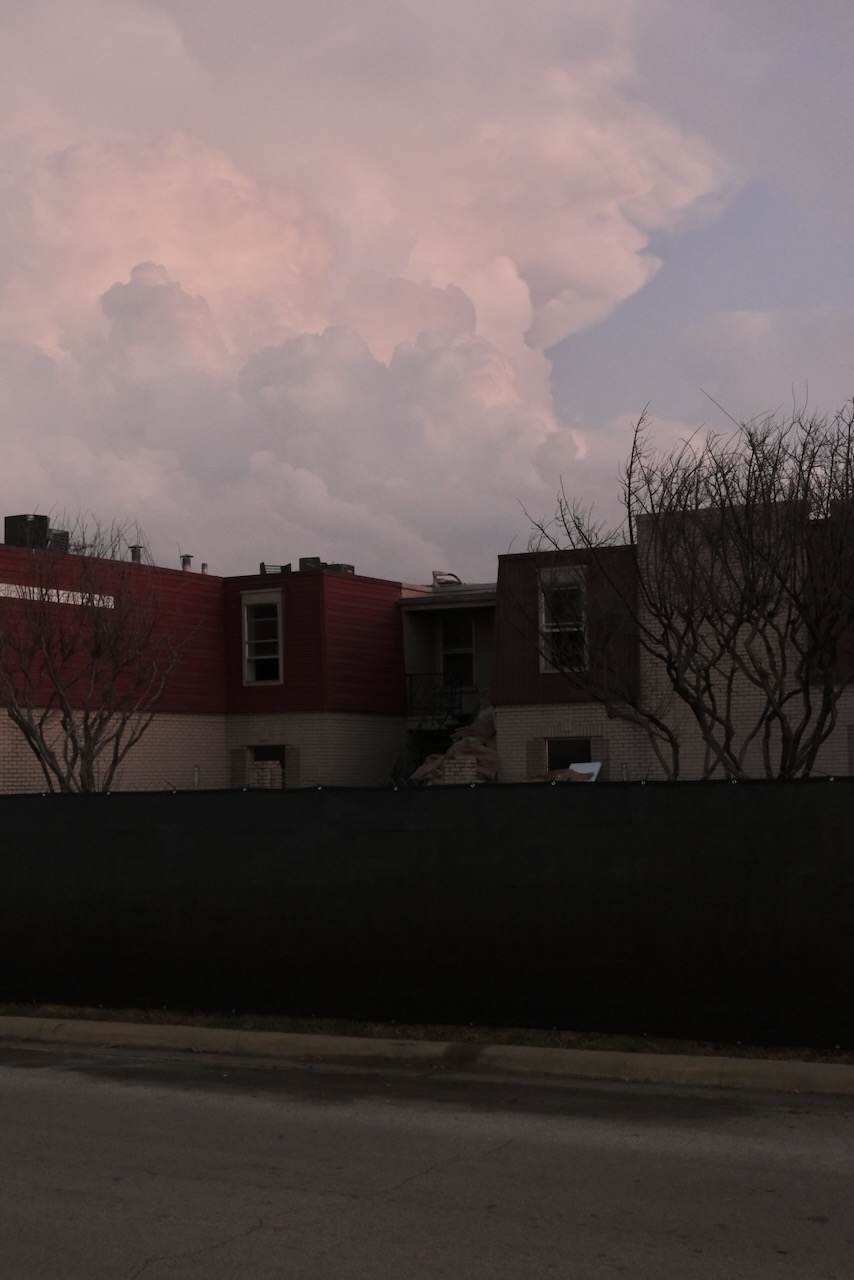 The doomed complex under storm clouds at dusk
