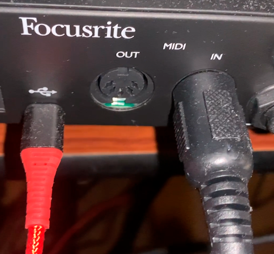 A picture of a Focusrite Scarlett's rear, showing a USB port, and 5-DIN MIDI input and output.