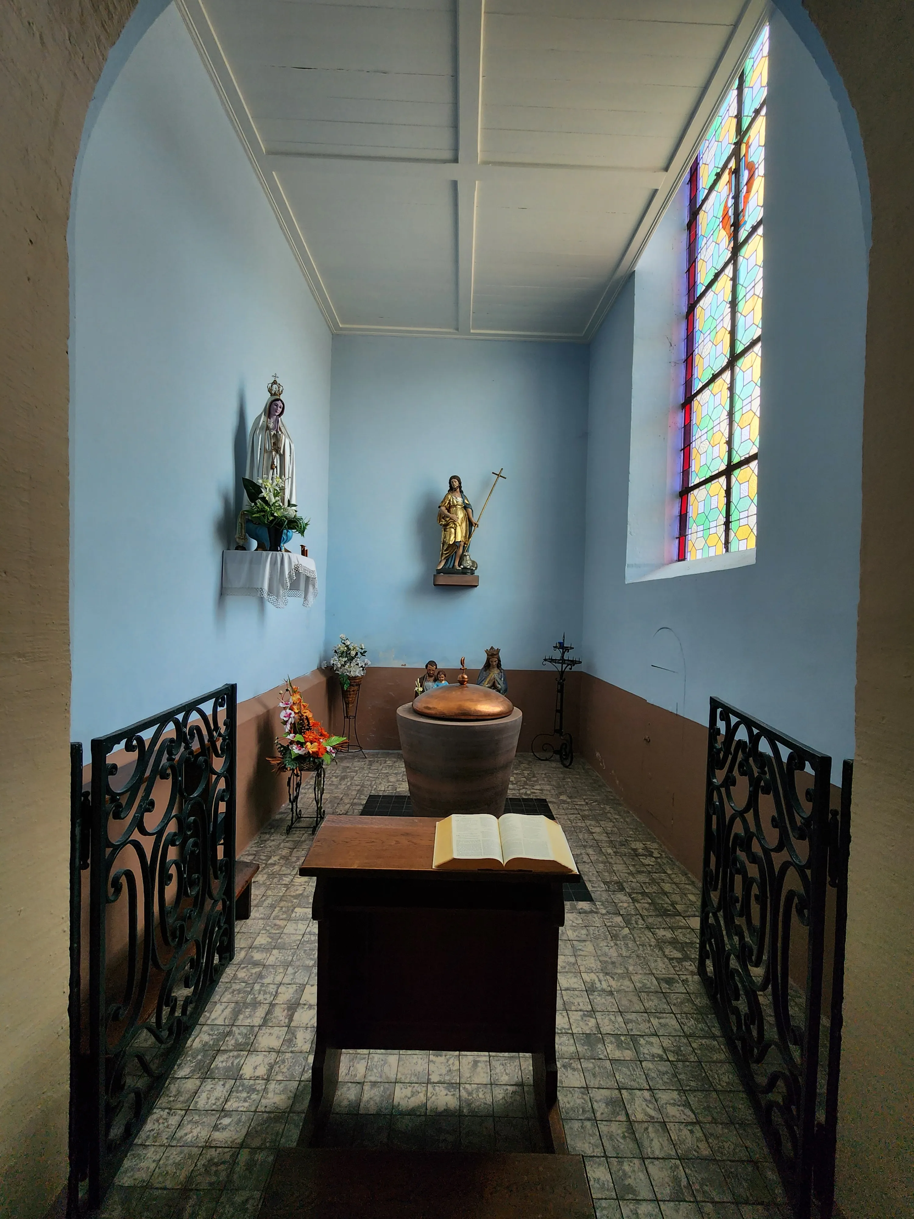Clôture de chœur en fer forgé à l'entrée de la chapelle baptismale