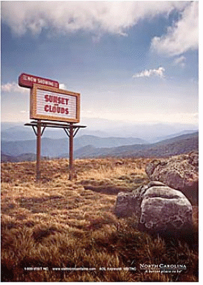 Advertisement with billboard in natural landscape with the words Now Showing Sunset and Clouds