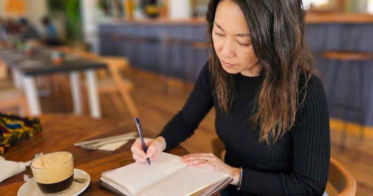 カフェで旅ノートを見返す女性 カフェで旅ノートを見返す女性