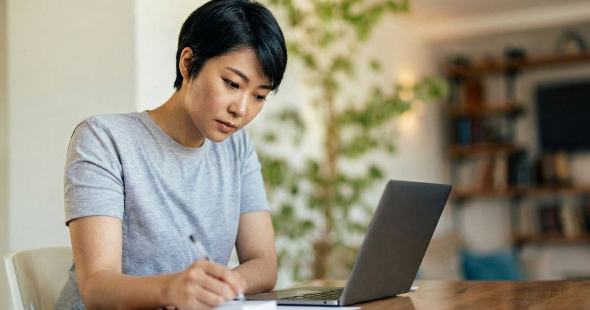 ノートに行動リストをペンで書き出す女性