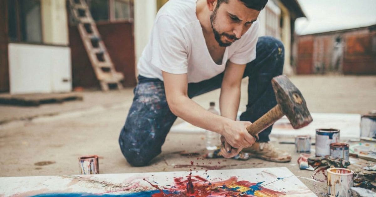 ハンマーで絵を描こうとしている人物のイラスト。適材適所の欠如を示す ハンマーで絵を描こうとしている人物のイラスト。適材適所の欠如を示す