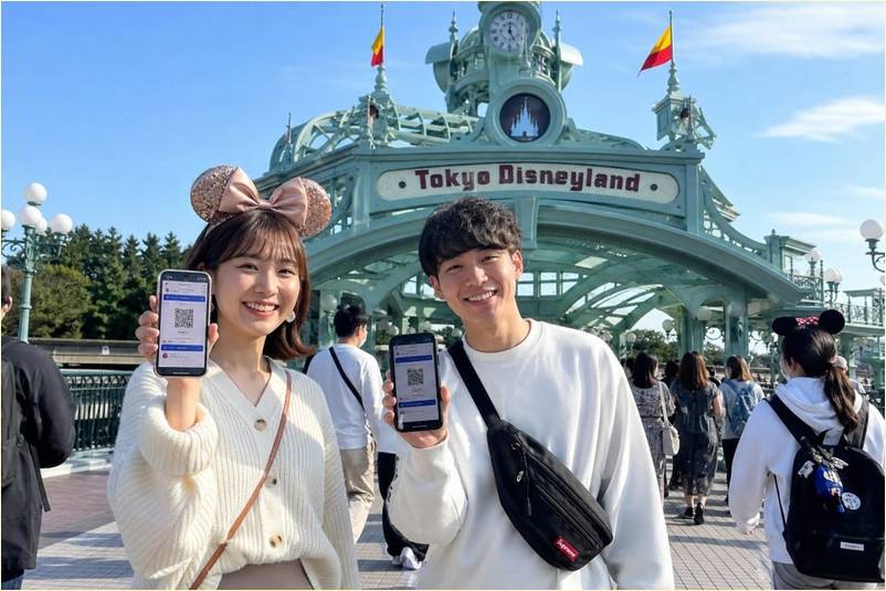 도쿄 디즈니랜드 입구에서 모바일 QR 티켓을 든 커플