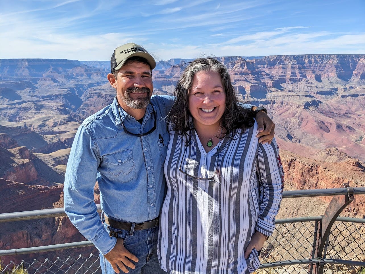 Adam Lazenby and his wife Shannon smiling together at the Grand Canyon, capturing a beautiful moment during their travels