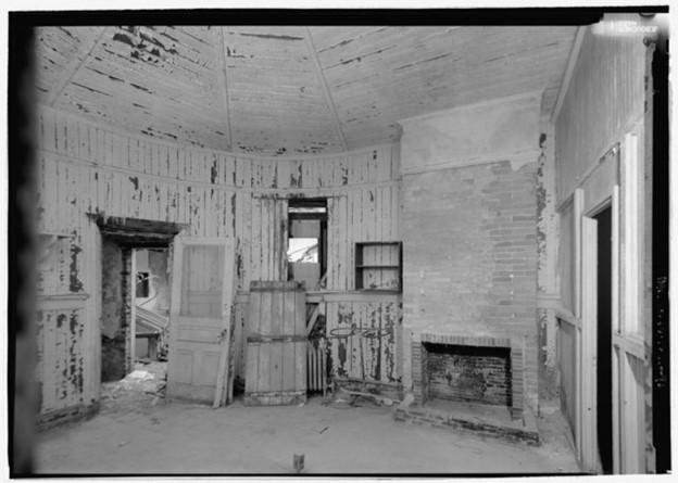 Image of abandoned chaplain's office with broken furniture and peeling paint.