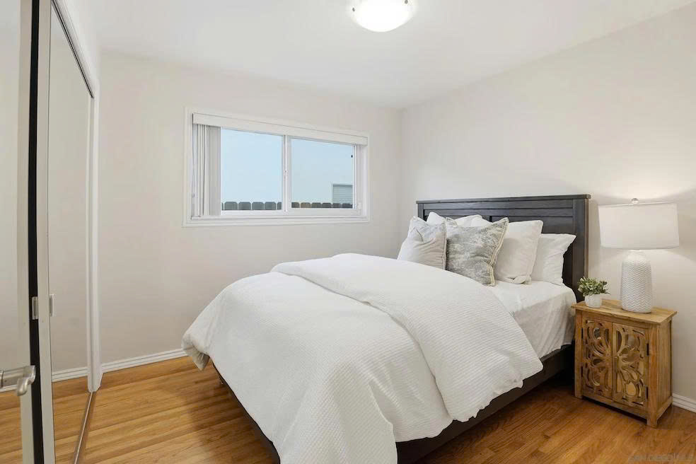 Cozy bedroom with hardwood floors and natural light