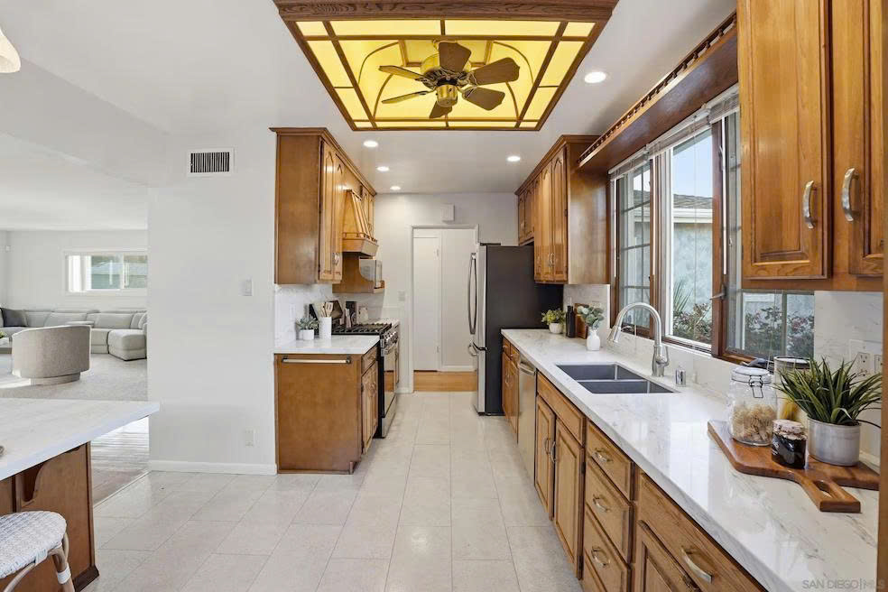Kitchen with stainless steel appliances, marble counters, and abundant cabinet storage
