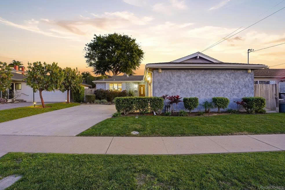 Front exterior view at sunset with manicured lawn and landscaping