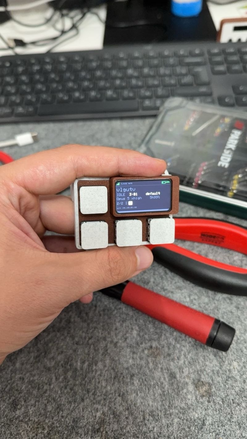 The assembled ESP32-S3 device held in a hand, four Kailh Choc keycaps and the colour screen lit