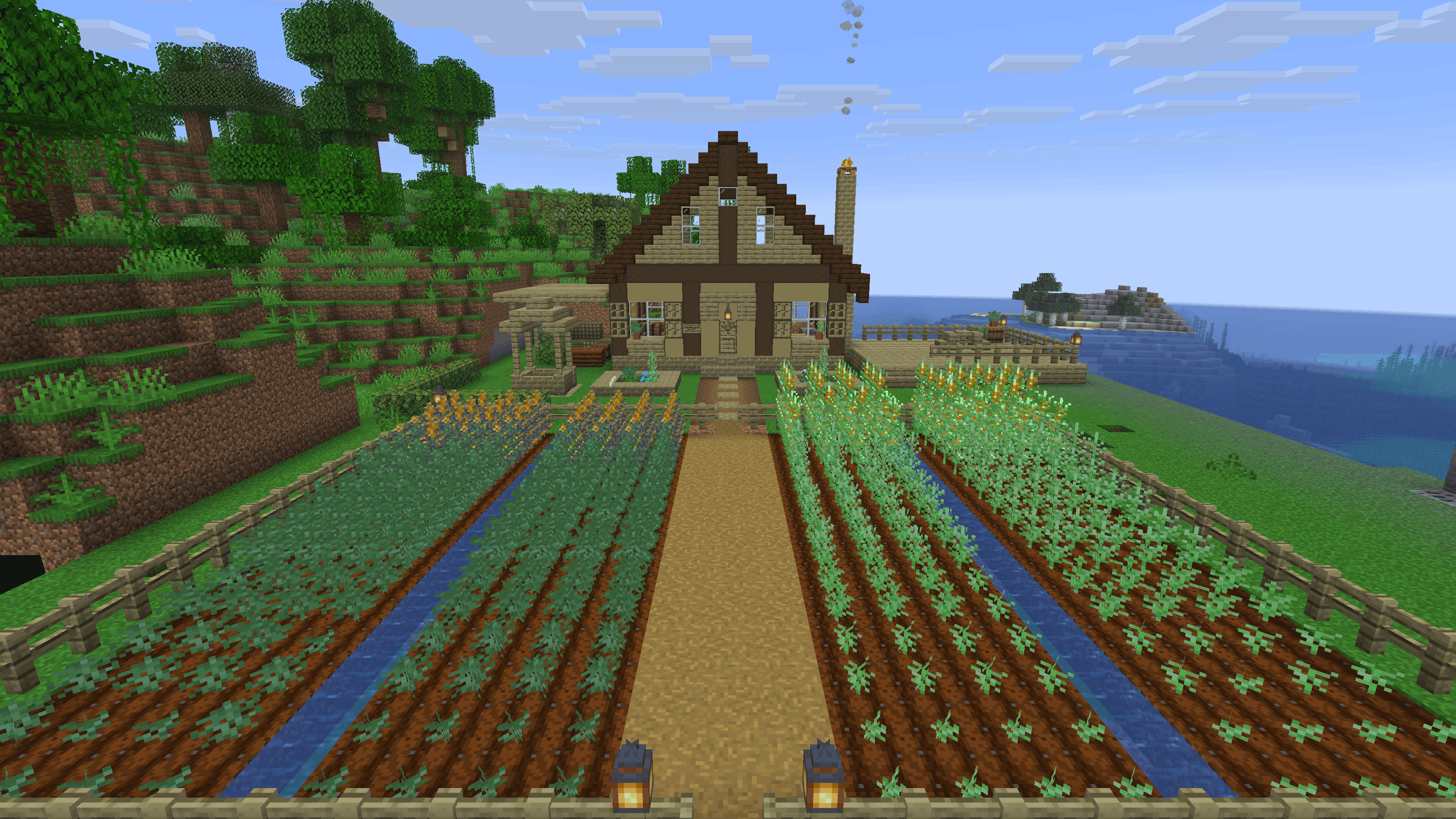 Two fenced hemp fields with irrigation channels, leading up to a house built from hemp