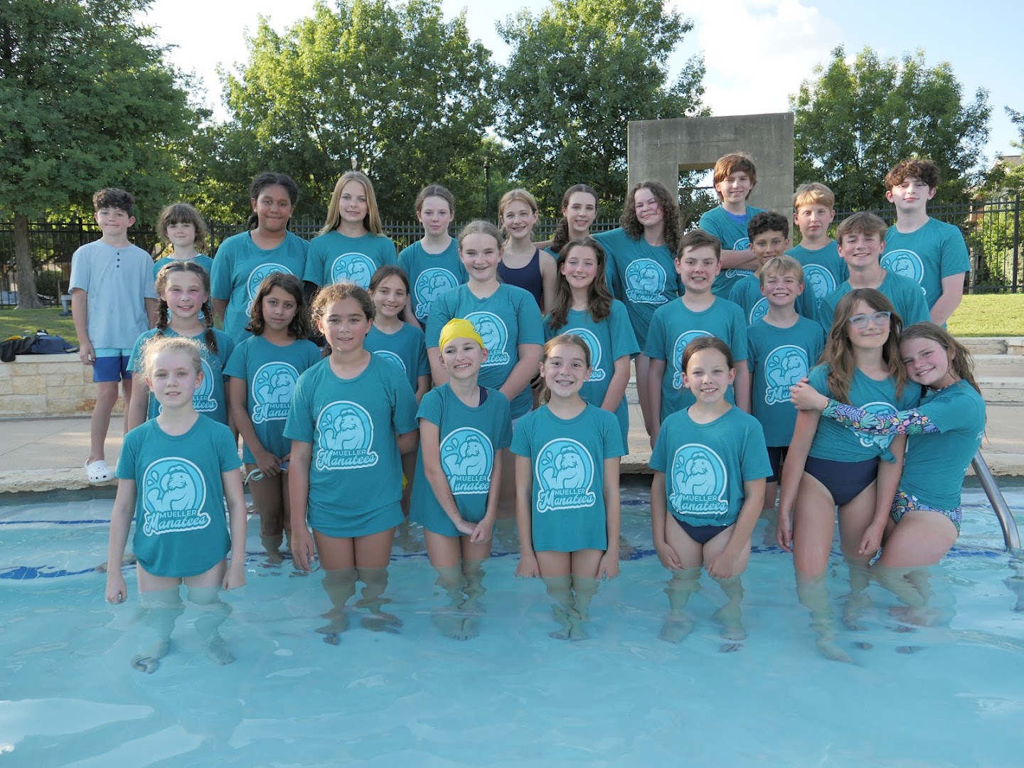 Mueller Manatees swimmers posing together in the pool.