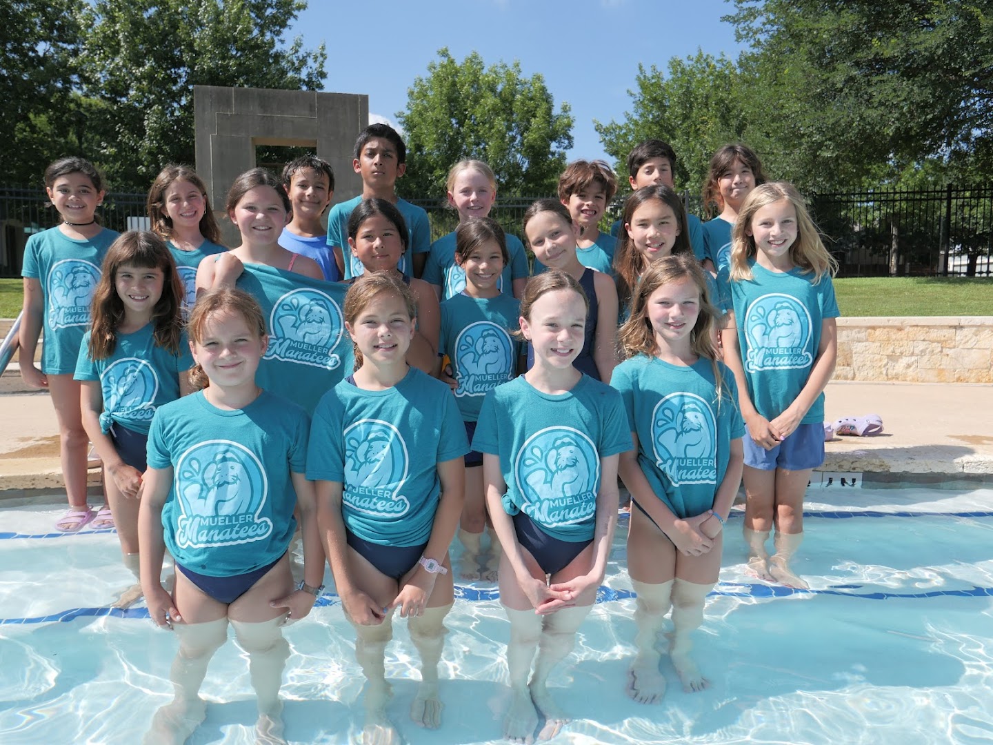 Mueller Manatees swimmers grouped together by the pool deck.