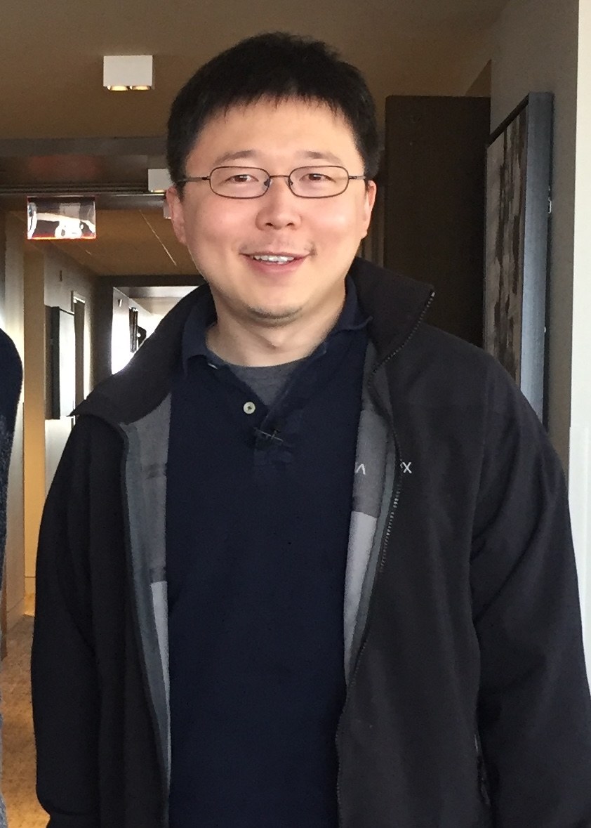 Portrait photo of Feng Zhang in a dark jacket and glasses