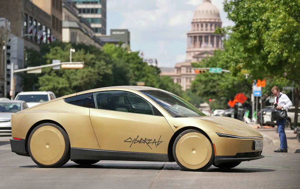 Gold Tesla Cybercab driving past the Texas State Capitol in downtown Austin
