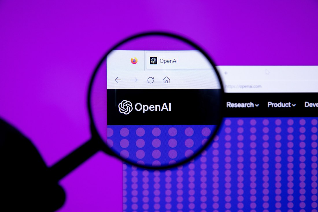 A magnifying glass held over the OpenAI logo on the openai.com website