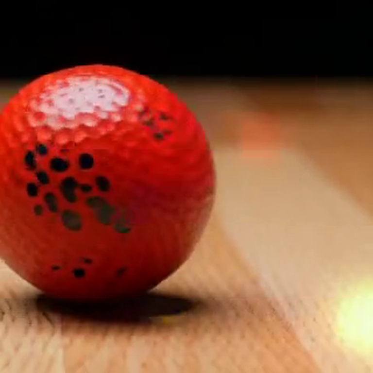 Generated frame: red ball on a wood table