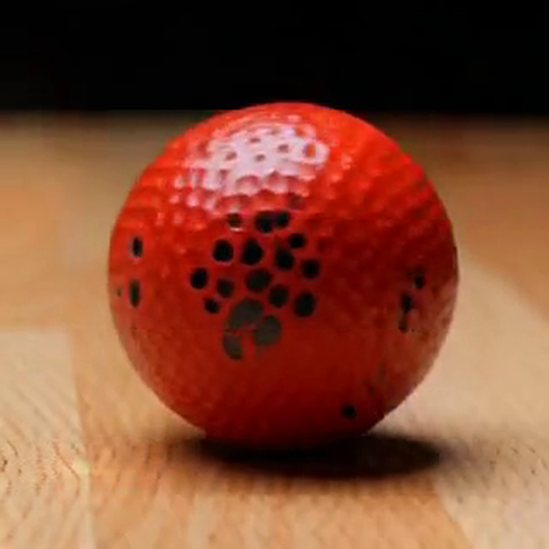 Another generated frame: red ball on wood table, later in the clip
