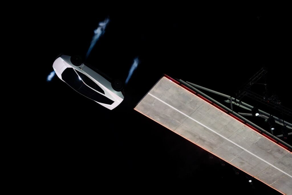 Roadster departing the top of the ramp with visible thruster plumes
