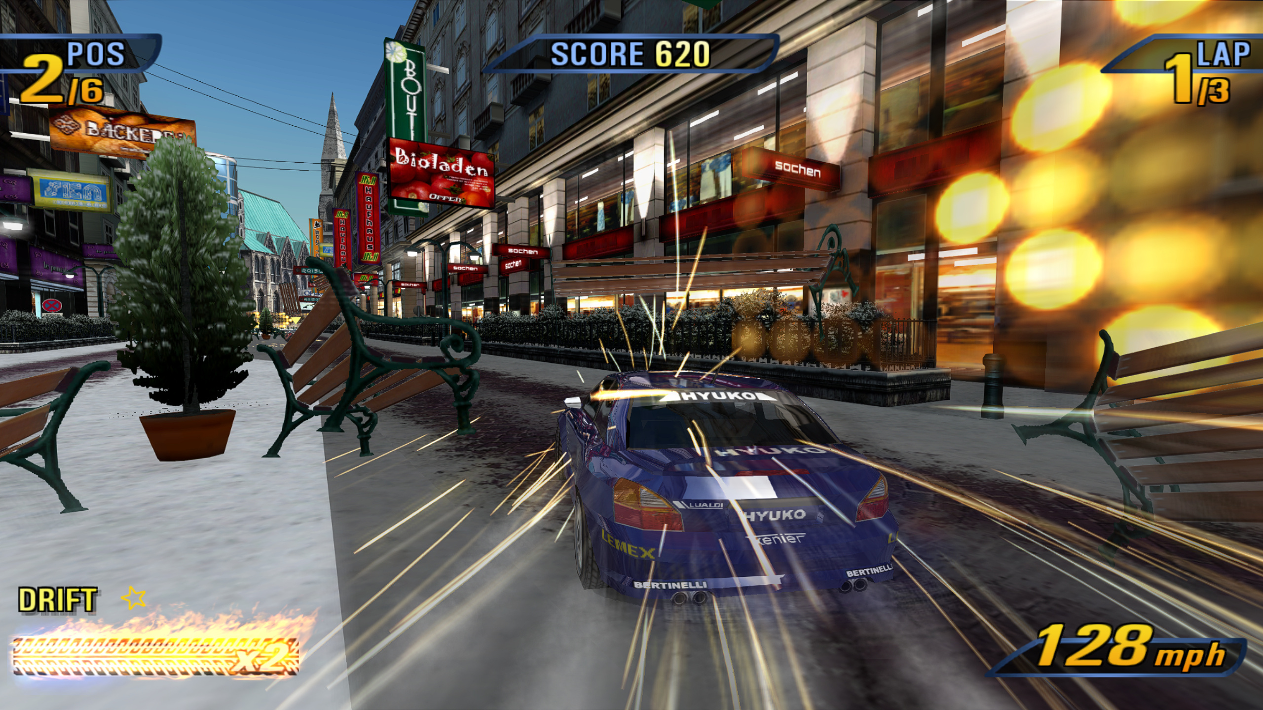 A race through a snowy European city: the player's blue car drifts past a row of shops, sparks flying as it clips a bench, a cathedral spire in the distance
