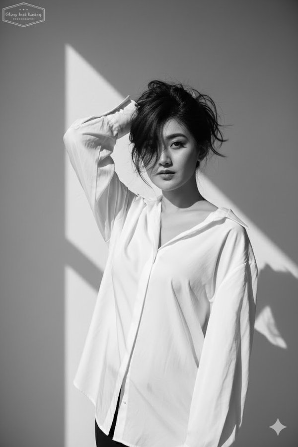 Create a black and white high-fashion editorial portrait of me, keeping my real face exactly as in the reference phot…