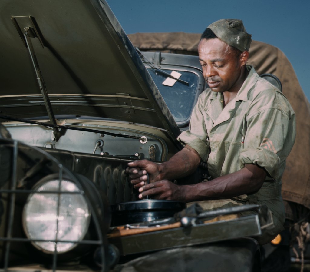 Photograph of a man fixing a truck.