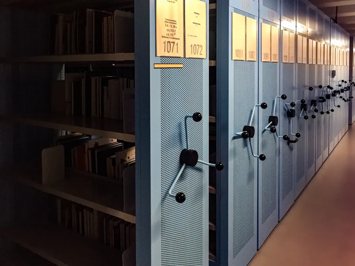 Books and binders on long library shelves